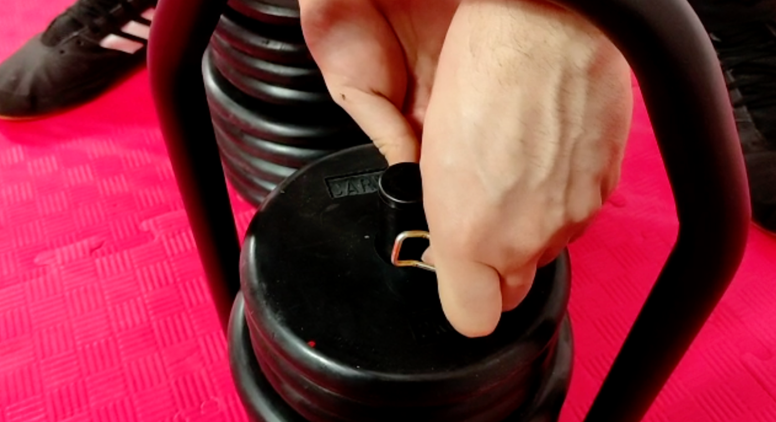 Hand operating the Regulabell locking mechanism to change weight plates